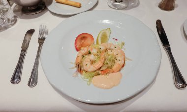 Bir tabak salata, karides ve sos.