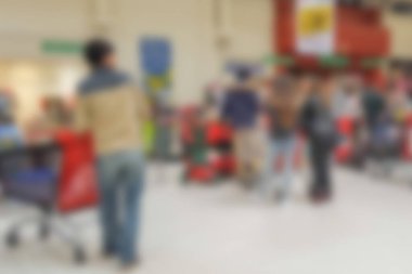 Soyut bulanık arkaplan: İnsanlar süpermarketten alışveriş yapıyor, müşteriler kasiyerlere ödeme yapmak için tezgahlarda arabalarıyla bekliyorlar. Alışveriş, müşteri konsepti.