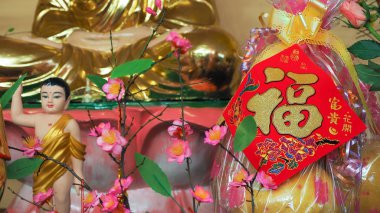 Arka planda Fu karakteri olan Buda heykeli Çin 'de yeni yılda sıklıkla görülen iyi şans anlamına gelir.