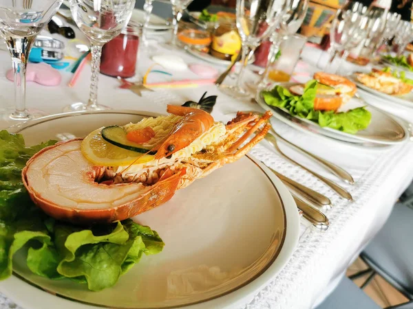 Festive table with dishes of lobsters, shrimps and mayonnaise