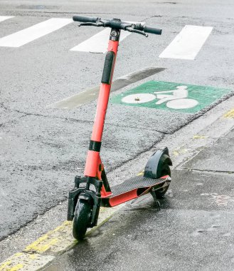 Kaldırımda kırmızı renkli elektrikli scooter.