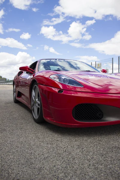 Kırmızı ferrari lüks araba güneşli bir yaz gününde yarış pistinde koşmaya hazır.