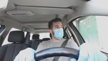 Çocuk, eldivenli ve maskeli bir araba kullanıyor.