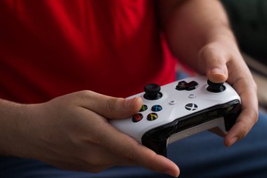 Çocuk bir Xbox oyun konsolunun kumandasıyla oynuyor. editoryal resim