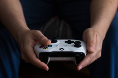 Çocuk bir Xbox oyun konsolunun kumandasıyla oynuyor. editoryal resim
