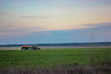 Traktör sonbaharda hasat için ilkbaharda tarlayı sürüyor, traktör sürücüsü..