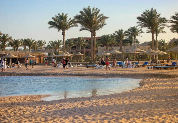 Lüks tatil köyü: güneşten korunmak için sahil ve saman şemsiyeler, deniz kenarında tembel yaz tatili, güneşli güzel bir gün..