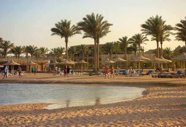 Lüks tatil köyü: güneşten korunmak için sahil ve saman şemsiyeler, deniz kenarında tembel yaz tatili, güneşli güzel bir gün..