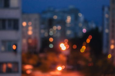 Akşam kenti manzarası ve penceresinde ışık olan evler: bulanık arkaplan