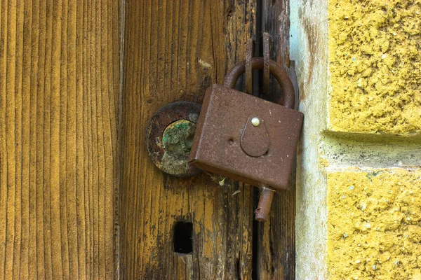 Antique textured door and rusty lock: no access to private property.