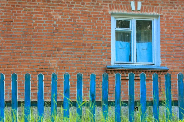 Niebieski Płot Tle Ceglanego Czerwonego Domu Miejscowości Lecie — Zdjęcie stockowe