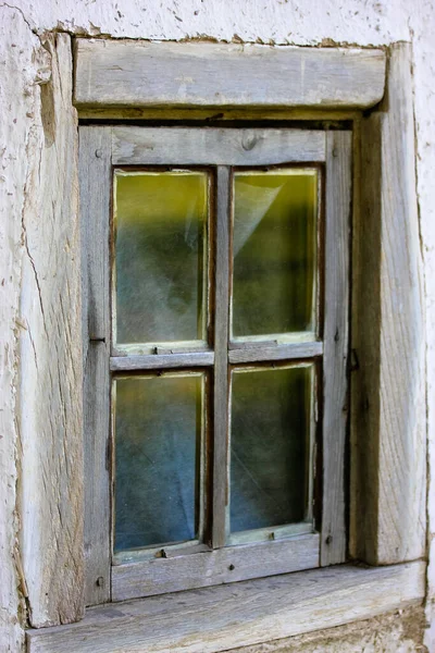 En gammal sprucken fönsterkarm i ett vitt hus i byn — Stockfoto