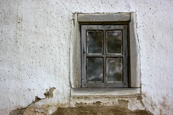 Un vieux cadre de fenêtre fissuré dans une maison blanche dans le village — Photo