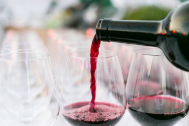 Beyaz arka plan kadar şarap cam yakın koyu yeşil bir şişe kırmızı şarap dökme