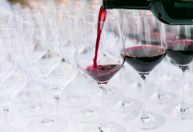 Beyaz arka plan kadar şarap cam yakın koyu yeşil bir şişe kırmızı şarap dökme