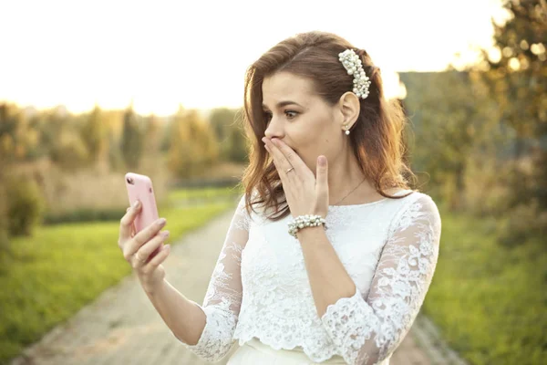 Hareket eden telefon içinde pembe kapak bakarak gelinlikle şok kız