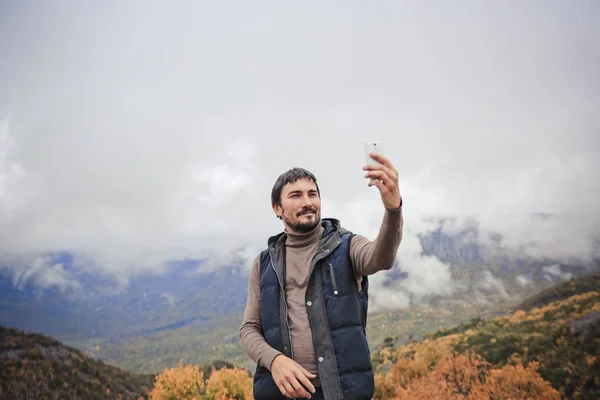 Trandy tatil selfie yağmurlu sonbahar dağ manzarası ile Smartphone bulutlu gökyüzü çıkart. Seyahat kavramı