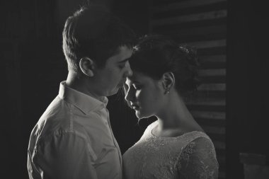 Genç gelin ile damat siluet düğün buket üzerinde beyaz bir arka plan ile