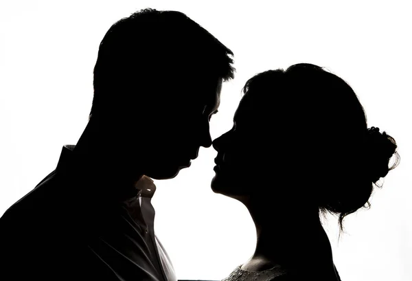 Genç gelin ile damat siluet düğün buket üzerinde beyaz bir arka plan ile