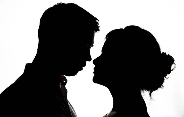 Genç gelin ile damat siluet düğün buket üzerinde beyaz bir arka plan ile