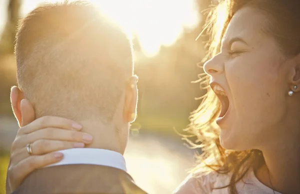 a young bride laughs and yells in the ear of the groom