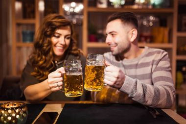 adam ve kız bir restoranda bira bardağı ile