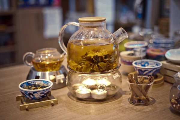 Ανθισμένο λουλούδι τσάι στην τσαγιέρα γυαλί με παραδοσιακή κινεζική αξεσουάρ διαμονή στον πίνακα στο teashop — Φωτογραφία Αρχείου