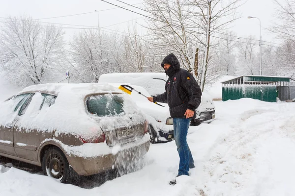 31 de janeiro de 2018. Moscovo. A Rússia. Um homem está limpando seu carro da neve após a neve pesada — Fotografia de Stock