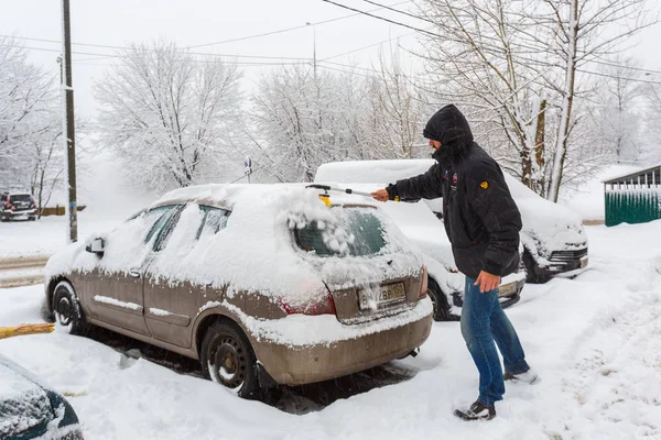 31 de janeiro de 2018. Moscovo. A Rússia. Um homem está limpando seu carro da neve após a neve pesada — Fotografia de Stock