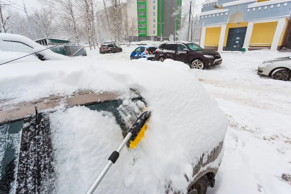 31 de enero de 2018. Moscú. Rusia. Un hombre está limpiando su coche de la nieve después de fuertes nevadas — Foto de Stock