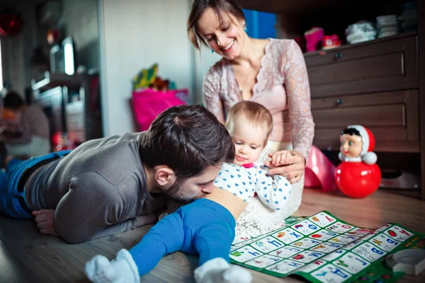 Pais jovens brincam com sua filhinha no chão. Muitos brinquedos. conceito de família feliz — Fotografia de Stock