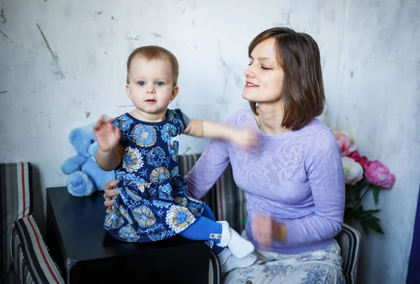 Feliz familia amorosa. Joven madre está jugando con su bebé en el interior —  Fotos de Stock