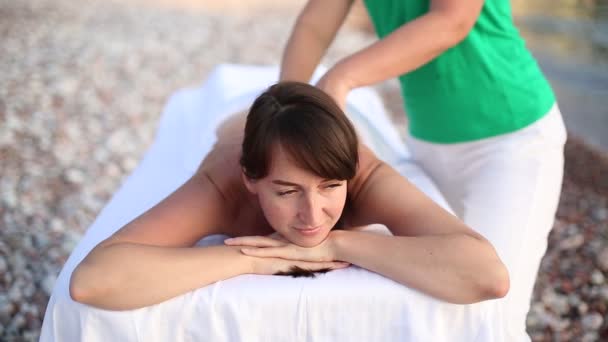 Mujer relajante masaje de espalda en la playa en la mesa de masaje. Mujer joven que tiene masaje en el spa. Cierre — Vídeos de Stock