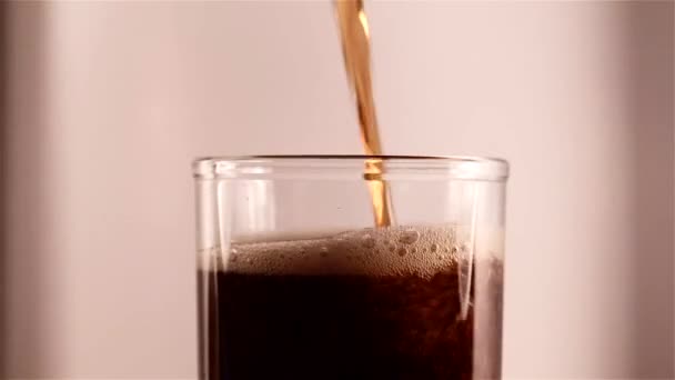 Cola froid est versé dans un verre avec de la glace .
