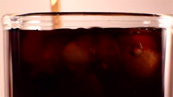 Cola froid est versé dans un verre avec de la glace . — Video