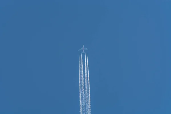 Samolot w niebo z smug kondensacyjnych. — Zdjęcie stockowe