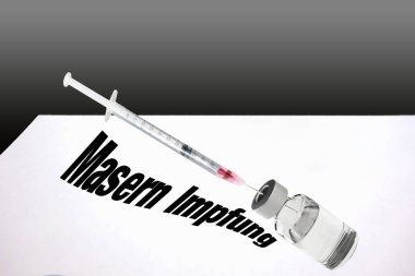 Syringe is filled with vaccine for measles vaccination.       clipart