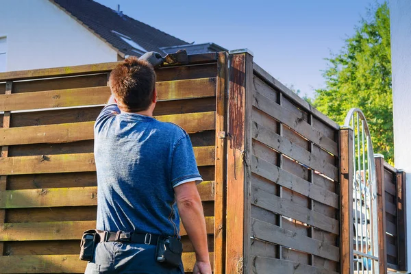 Accarezzando lacca protettiva su una recinzione di legno — Foto Stock