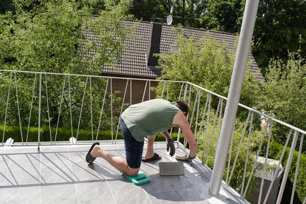 Poser les carreaux sur le sol d'un balcon et le coulis . — Photo