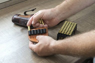 Adam bir mühimmat tabanca yüklenmesi