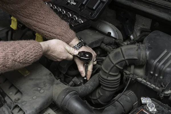 Автомеханик чинит автомобильный двигатель инструментами — стоковое фото