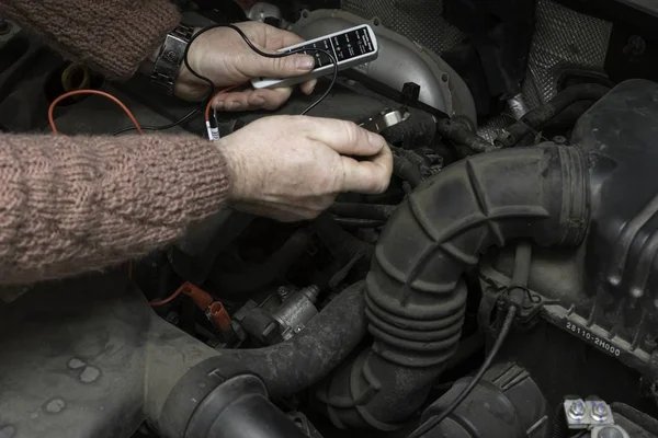 Автомобільний механізм фіксує двигун автомобіля за допомогою інструментів — стокове фото