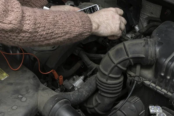 Mechanik samochodowy rozwiązuje silnik samochodu przez narzędzia — Zdjęcie stockowe