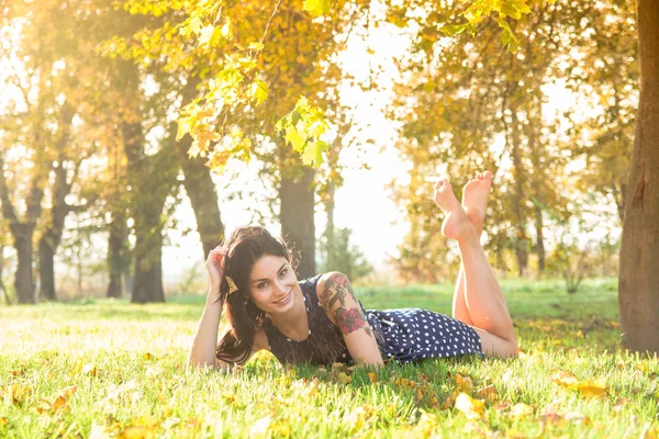 Sonbahar sonbaharı çimlerin üzerinde güzel bir kız.