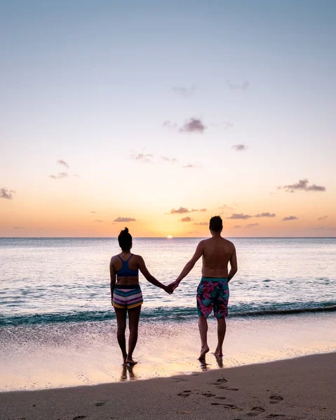 Pár séta a strandon naplementekor a Saint Lucia szigeten, trópusi strand St Lucia sziget — Stock Fotó