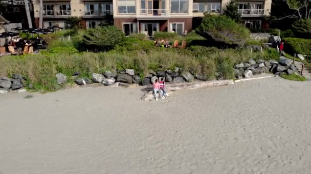 Tofino Vancouver Island, flygutsikt på stranden i Tofino med människor som surfar under solnedgången Vancouver Island Kanada, par promenader på stranden — Stockvideo