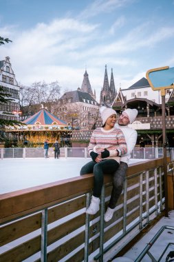 Genç çift, şehir gezisi sırasında Köln Almanya 'daki Noel pazarını, Noel pazarındaki kadın ve erkekleri ziyaret ediyor.