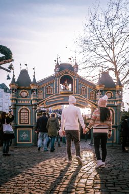 Genç çift, şehir gezisi sırasında Köln Almanya 'daki Noel pazarını, Noel pazarındaki kadın ve erkekleri ziyaret ediyor.