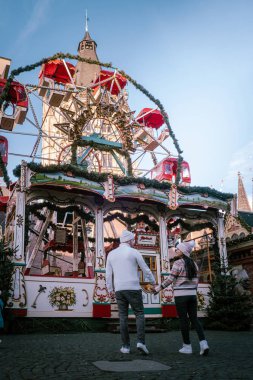 Genç çift, şehir gezisi sırasında Köln Almanya 'daki Noel pazarını, Noel pazarındaki kadın ve erkekleri ziyaret ediyor.
