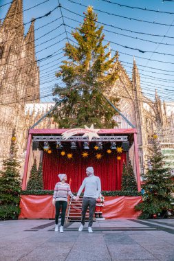 young couple visit the Christmas market in Cologne Germany during a city trip, men and woman at Christmas market clipart